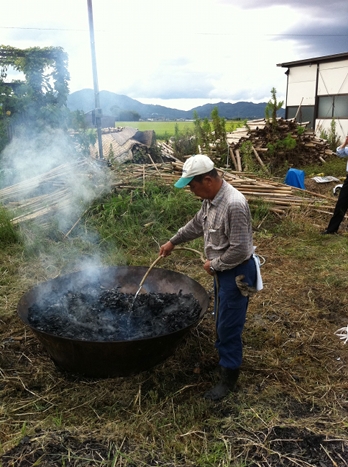 Man putting water on burnt bamboo